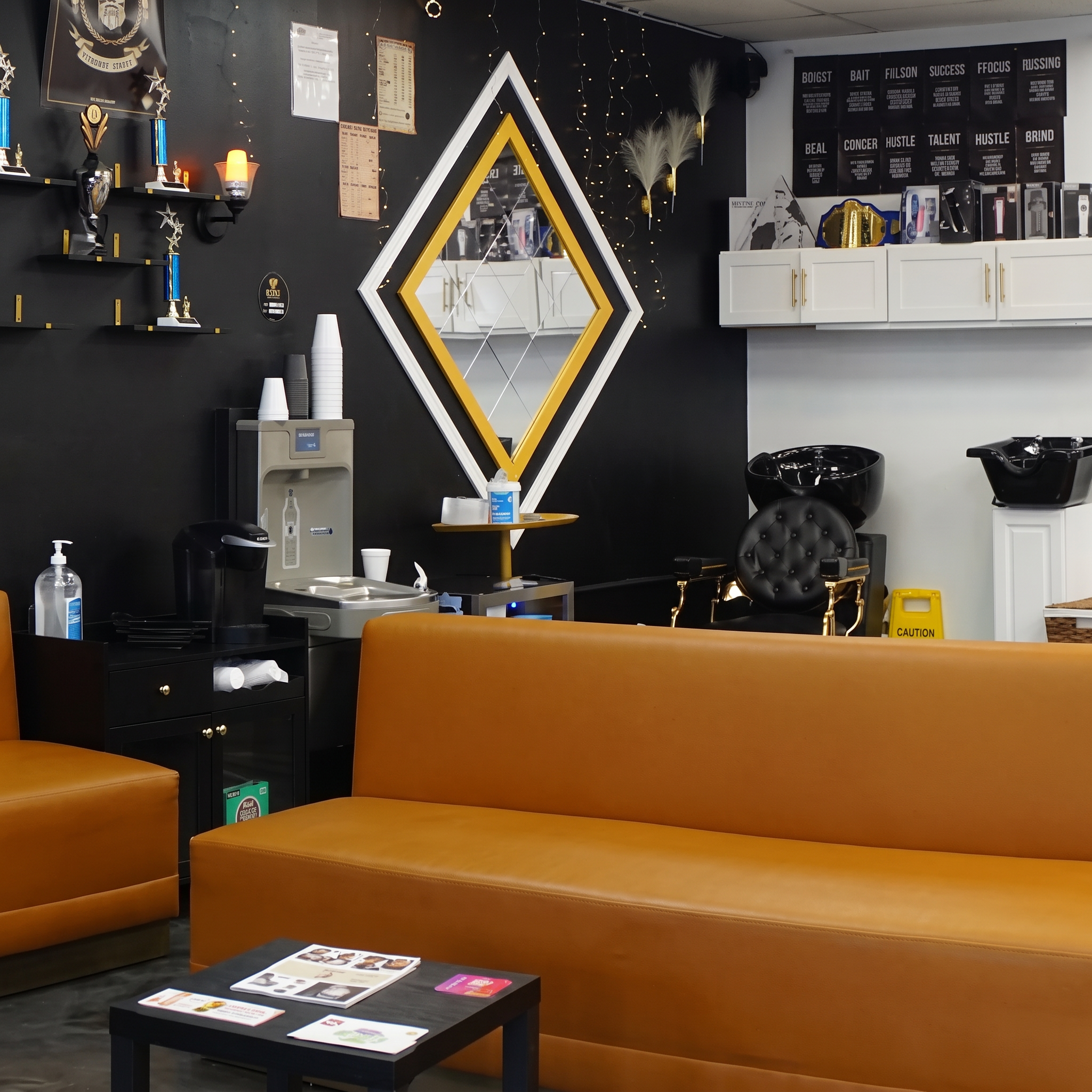 Waiting lounge with coffee station and leather seating inside Top Trend Barbershop