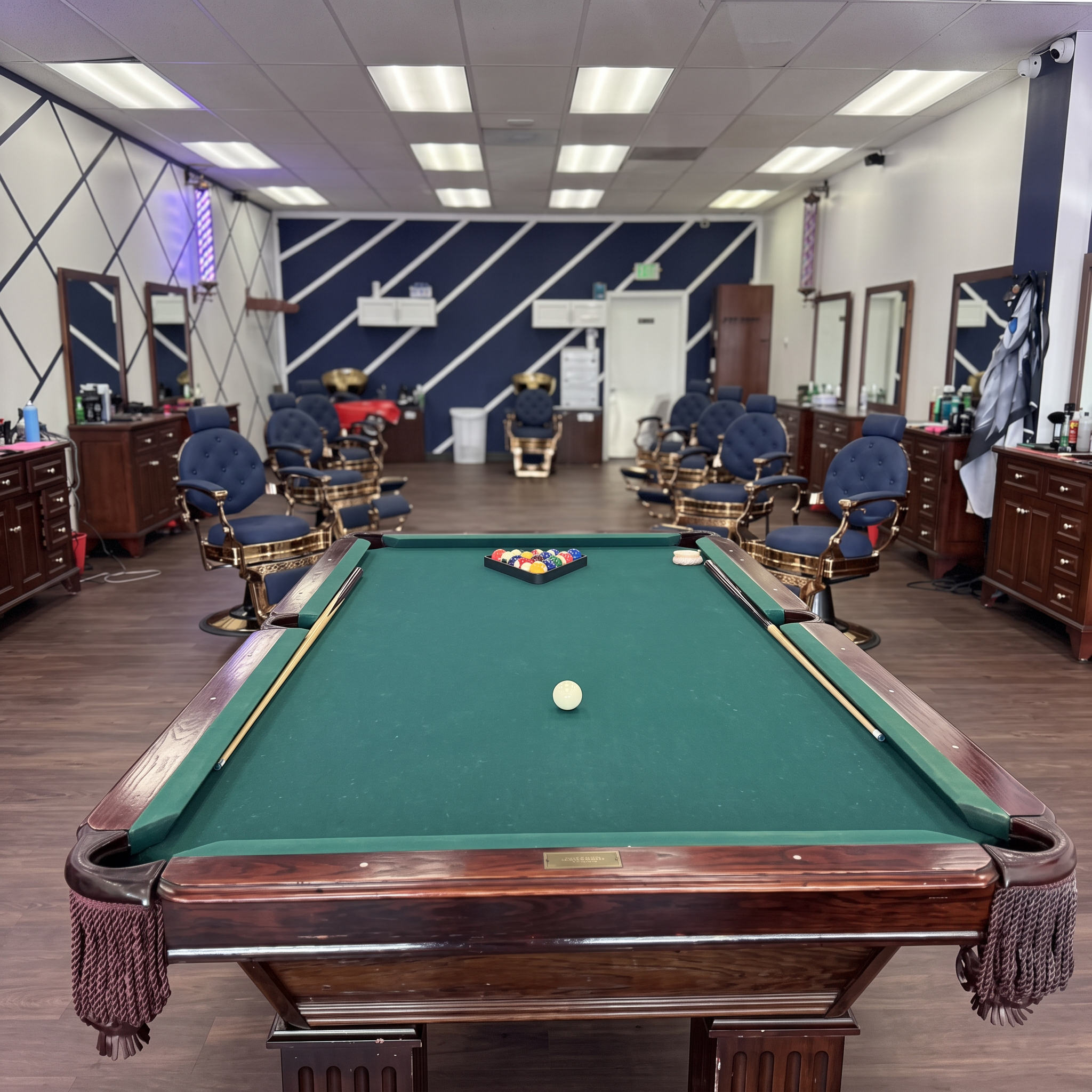 Pool table and barber chairs inside Top Trend Barbershop